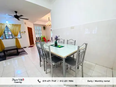 a dining room with a table and chairs at Prairie Villa Homestay in Lumut