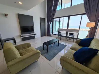 a living room with two couches and a television at Sunrise Gurney Executive Premium Suite in George Town