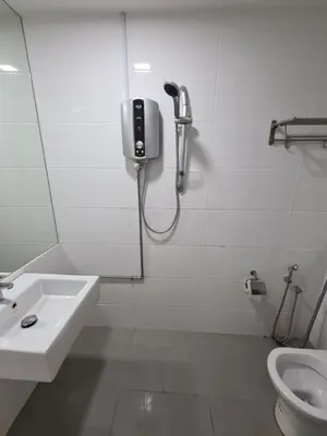a bathroom with a shower and a sink and a toilet at Sunrise Gurney Executive Premium Suite in George Town