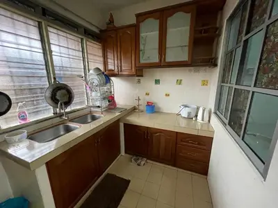 a small kitchen with wooden cabinets and a sink at Homestay Bidor DMaju in Bidur