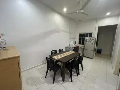 a kitchen with a table and chairs and a refrigerator at Homestay Bidor DMaju in Bidur