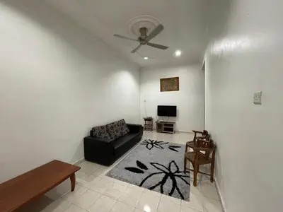 a living room with a black couch and a tv at Homestay Bidor DMaju in Bidur