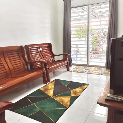a living room with a bench and a rug at Homestay Inap Bakawali Seri Iskandar in Seri Iskandar