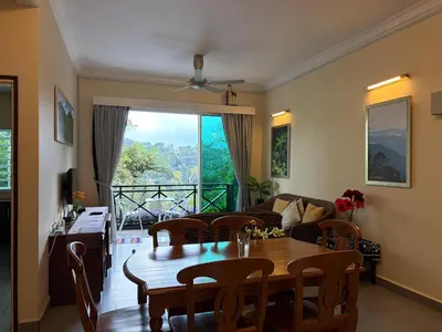 a living room with a table and a couch at Gerard's Place Nature Heaven Apartment in Tanah Rata