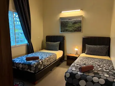 a bedroom with two beds and a window at Gerard's Place Nature Heaven Apartment in Tanah Rata