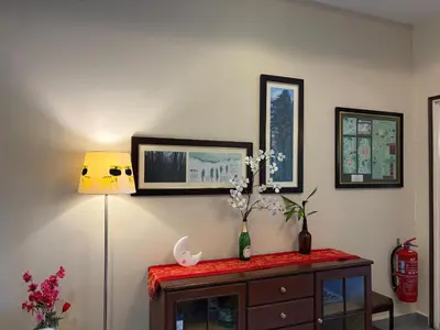 a room with a table with a lamp and flowers on it at Gerard's Place Nature Heaven Apartment in Tanah Rata