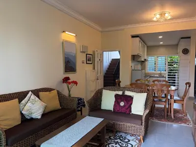 a living room with two couches and a table at Gerard's Place Nature Heaven Apartment in Tanah Rata