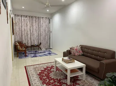 a living room with a couch and a table at Rose Homestay in Sitiawan