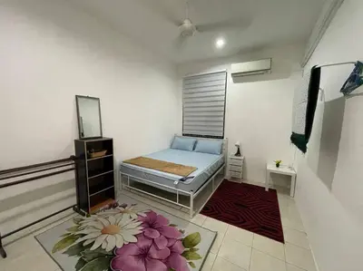 a small room with a bed and a mirror at Rose Homestay in Sitiawan