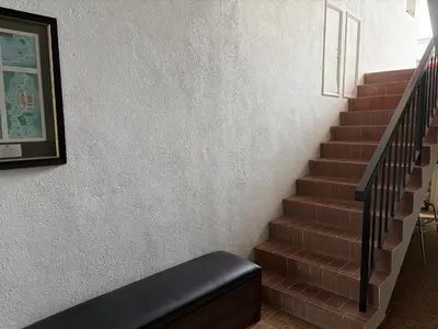a stairway with a stair case and a picture on the wall at Gerard's Place Nature Haven Apartment in Tanah Rata