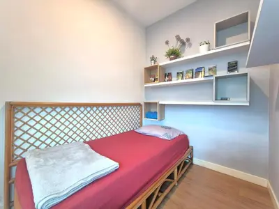 a small bedroom with a bed with a red blanket at FERRINGHI RESORT 5-BEDROOM with POOL, BBQ SET, WiFi, Netflix & WALK to BEACH in Batu Ferringhi