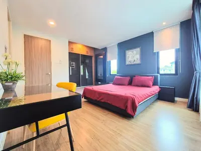 a bedroom with a bed and a table in it at FERRINGHI RESORT 5-BEDROOM with POOL, BBQ SET, WiFi, Netflix & WALK to BEACH in Batu Ferringhi