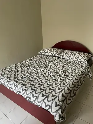 a bed with a black and white comforter on it at To' Teh Homestay in Ipoh