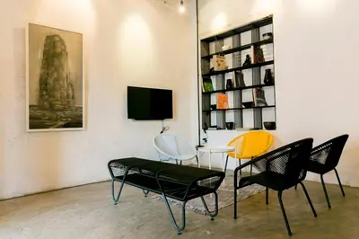 a room with chairs and a table and a tv at Central Georgetown - Loft House in George Town