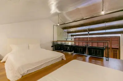 a bedroom with two beds and a balcony at Central Georgetown - Loft House in George Town