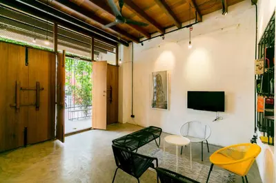 a room with a table and chairs and a tv at Central Georgetown - Loft House in George Town