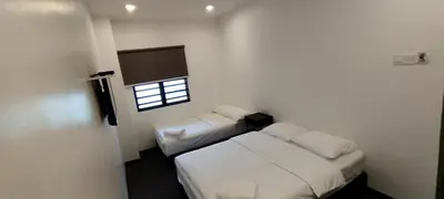 a bedroom with two beds and a window at Olive Bedz Hotel in Tambun