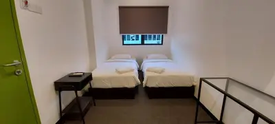two beds in a small room with a window at Olive Bedz Hotel in Tambun