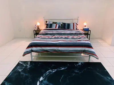 a bedroom with a large bed with a blue and white blanket at Spacious cozy Lakeville homestay 4 bedrooms all with AirCond in Seri Iskandar
