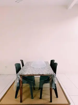 a glass table with four chairs in a room at Spacious cozy Lakeville homestay 4 bedrooms all with AirCond in Seri Iskandar