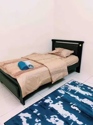 a bed in a bedroom with a rug on the floor at Spacious cozy Lakeville homestay 4 bedrooms all with AirCond in Seri Iskandar