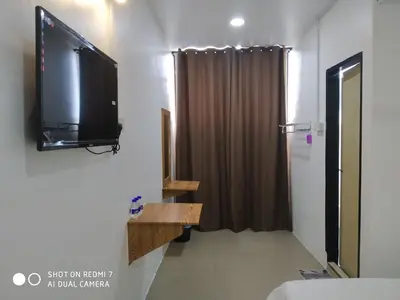 a room with a television on a wall with a curtain at Hotel station 24 in Sungai Besar