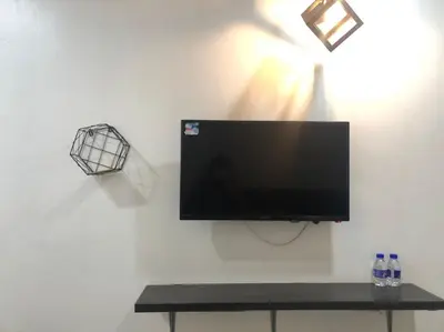 a flat screen tv hanging on a white wall at Hotel station 24 in Sungai Besar