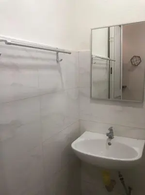 a white bathroom with a sink and a mirror at Hotel station 24 in Sungai Besar