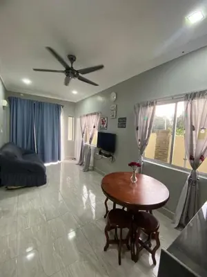 a living room with a table and a ceiling fan at MAMA homestay in Bagan Serai