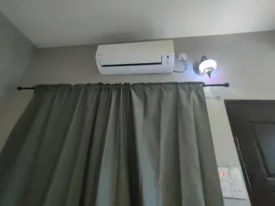 a room with a window curtain and a air conditioner at MAMA homestay in Bagan Serai