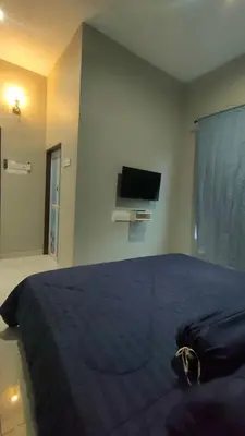 a bedroom with a bed and a flat screen tv at MAMA homestay in Bagan Serai