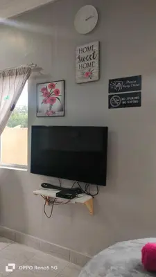a flat screen tv on a wall in a bedroom at MAMA homestay in Bagan Serai