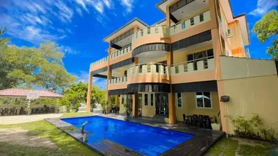 a house with a swimming pool in front of it at Homestay Seri Pangkor in Pangkor