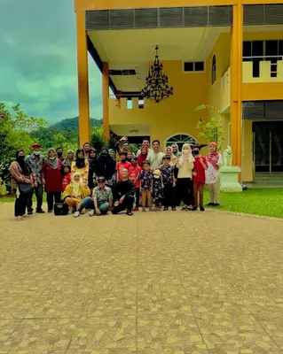 a group of people posing for a picture in front of a building at Homestay Seri Pangkor in Pangkor