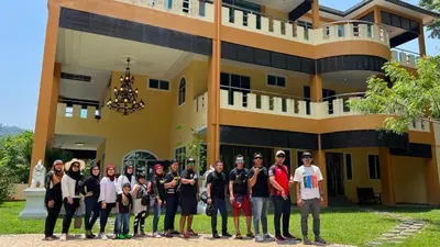 a group of people standing in front of a building at Homestay Seri Pangkor in Pangkor