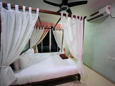 a bedroom with a bed with a ceiling fan at Homestay Seri Pangkor in Pangkor