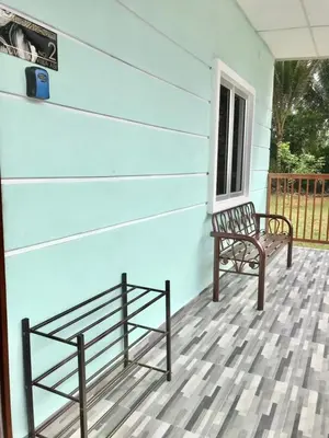 two benches sitting on the front porch of a house at Teratak Ar-Rayyan x Villa Abi in Batu Kurau