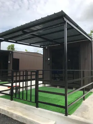 a metal pavilion with a black roof on a field of grass at Teratak Ar-Rayyan x Villa Abi in Batu Kurau