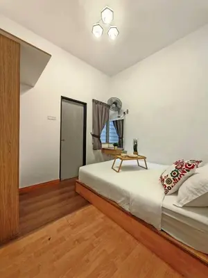 a bedroom with a bed with a table on it at W25 atGoldenHills NightMarket WiFi 4R in Brinchang