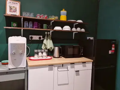 a kitchen with a counter with a microwave and a refrigerator at Walk-Up To SIAR - Children Not Allowed in Cameron Highlands