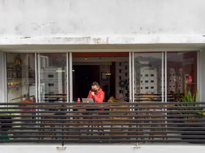 a man standing in front of a building with a laptop at Walk-Up To SIAR - Children Not Allowed in Cameron Highlands