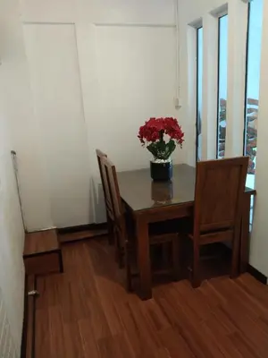 a dining room table with a vase of flowers on it at khairul homestay taman tengiri seberang jaya in Kampong Telok