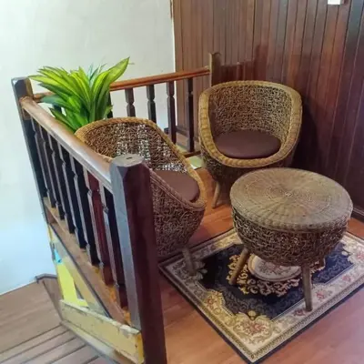 two wicker chairs and a plant in a room at khairul homestay taman tengiri seberang jaya in Kampong Telok