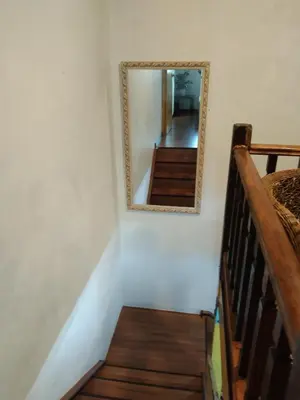 a mirror hanging on a wall next to a stairway at khairul homestay taman tengiri seberang jaya in Kampong Telok