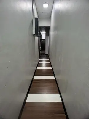 a hallway with a long corridor with wooden floors at Hotel Rasa Sayang 2 in Tanah Rata