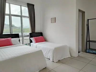 two beds in a room with a window at W6WarmStay@GoldenHills/3RPenthouse/WiFi/PasarMalamView/2carpark in Brinchang