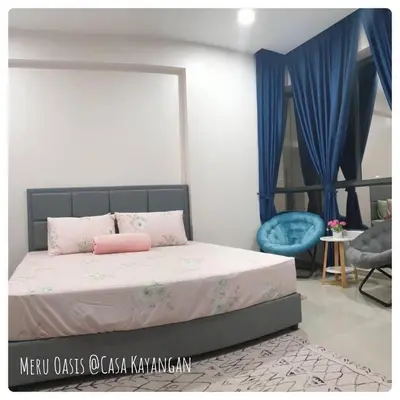 a bedroom with a bed and a blue chair at Meru Oasis at Casa Kayangan Ipoh in Ipoh