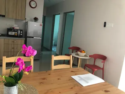 a kitchen and dining room with a wooden table at Meru Oasis at Casa Kayangan Ipoh in Ipoh