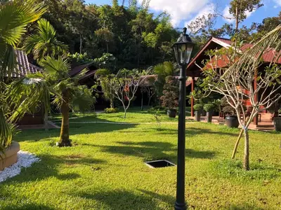 a street light in a yard with palm trees at Kemuning Orchard Villaa in Kerling