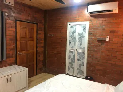 a room with a brick wall with a glass door at Kemuning Orchard Villaa in Kerling